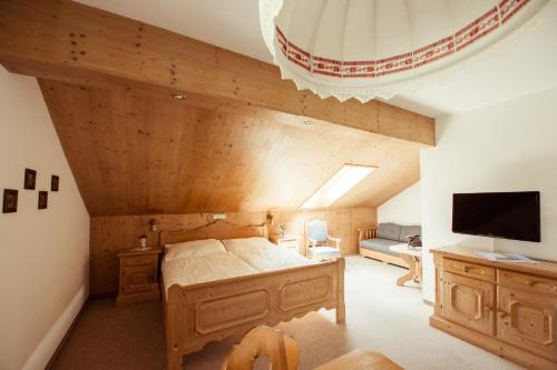 a bedroom with a bed and a tv in a room at Frühstückspension Windlegern in Neukirchen