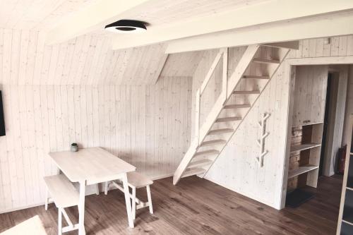 a room with a staircase and a table and chairs at Retro chaty Soběšky in Horní Soběšovice