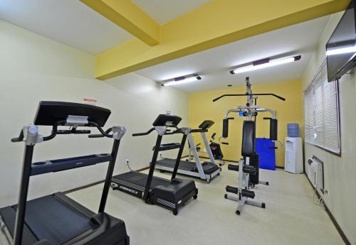 a gym with several tread machines in a room at Curi Palace Hotel in Pelotas