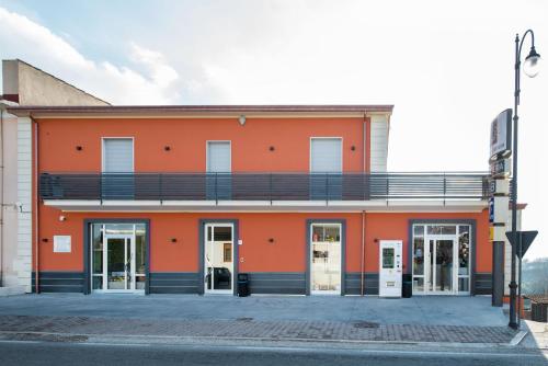 ein orangefarbenes Gebäude mit Balkon auf einer Straße in der Unterkunft Regina Viarum in Mirabella Eclano