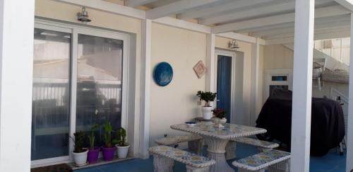 a room with two tables and a balcony with plants at CASA CAMPISI Marzamemi in Marzamemi
