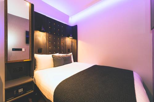 a hotel room with a bed and a television at Point A London Liverpool Street in London