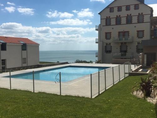 une clôture autour d'une piscine à côté d'un bâtiment dans l'établissement Gîte horizon mer et campagne, à Pornic