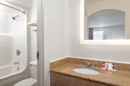 a bathroom with a sink and a toilet and a mirror at Howard Johnson by Wyndham Rock Hill in Rock Hill
