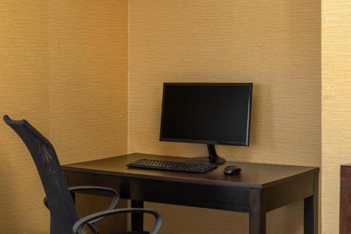 a desk with a computer monitor and a keyboard and mouse at Howard Johnson by Wyndham Rock Hill in Rock Hill
