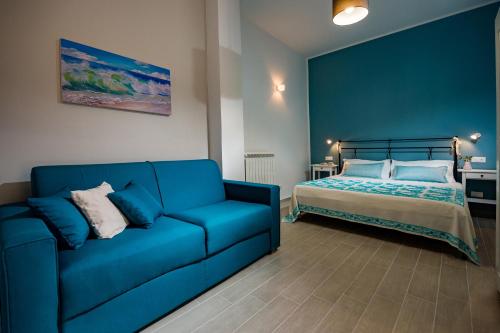 a blue couch and a bed in a room at Annina'S Home Panoramic sea view By Sicily Home Solutions in Castellammare del Golfo