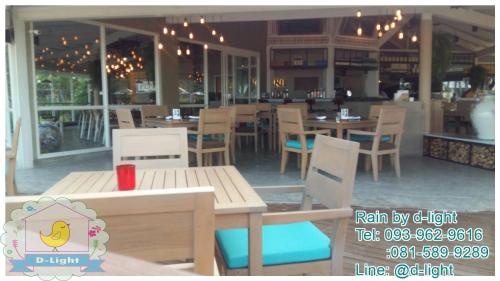 a restaurant with wooden tables and chairs and a dining area at Rain Cha-am Hua Hin by D-light in Cha Am