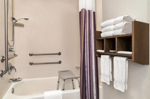 a bathroom with a tub and a toilet and towels at La Quinta Inn and Suites by Wyndham at WaTiki Waterpark in Rapid City