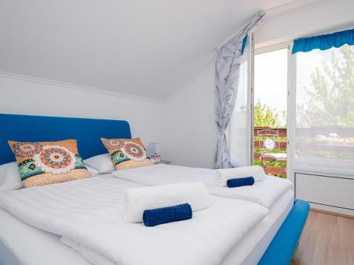a white bed in a room with a window at Casa Montana Apartments in Balatonalmádi