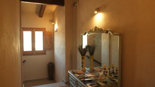 een badkamer met een spiegel en een dressoir met kaarsen bij La Masia de Montpedrós in Peralada