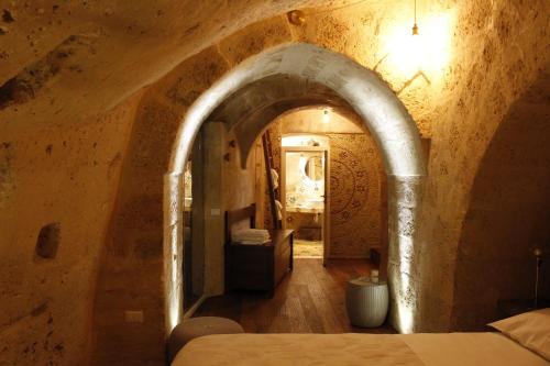a bedroom with an archway in a stone building at Casa Linda in Matera