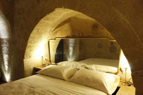 Un dormitorio con una cama en una pared de piedra. en Casa Linda, en Matera