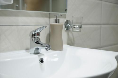 La salle de bains est pourvue d'un lavabo et d'un robinet. dans l'établissement Apartman Baron, à Višegrad