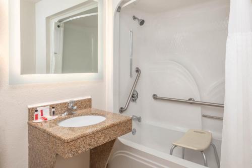 a bathroom with a sink and a mirror and a toilet at Howard Johnson by Wyndham Rock Hill in Rock Hill