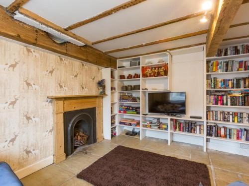 a living room with a fireplace and a tv and bookshelves at Bamse Self-Catering Ensuite Rooms with Shared Kitchen in Montrose