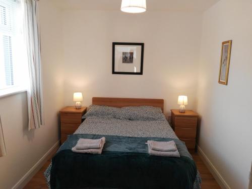 a bedroom with a bed with two towels on it at Elm Cottage in Cong