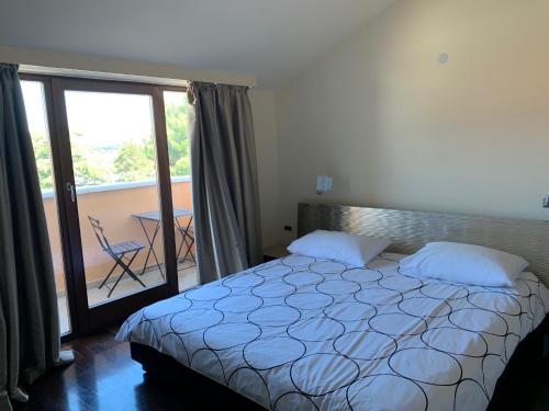 a bedroom with a bed and a balcony at Hotel Villa Cittar in Novigrad Istria