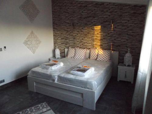 ein großes Bett in einem Zimmer mit Ziegelwand in der Unterkunft Apartamentos Sao Rafael, 80b in Albufeira