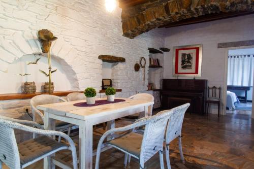 a dining room with a white table and chairs at Sun Holiday House in Pisses