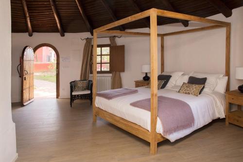 a bedroom with a wooden bed with a wooden canopy at Hotel Rural Las Tejuelas in Valdecaballeros