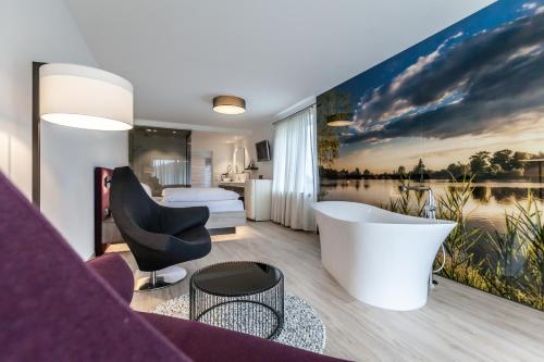 ヴォルフアッハにあるBollenhuthotel Kirnbacher Hofのバスタブ付きのホテルルームとベッドルーム1室が備わります。