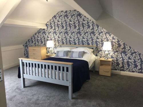 a bedroom with a bed with blue and white wallpaper at Sunderland Self-Catering 1 -Chester Cottage in Sunderland