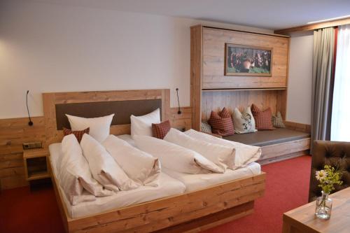 ein großes Bett mit Kissen darauf in einem Zimmer in der Unterkunft Hotel Garni Alpina in Damüls