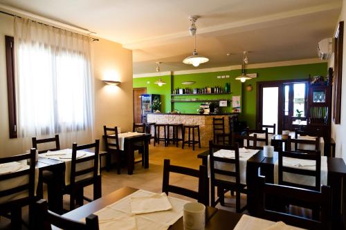 un ristorante con tavoli e sedie e un bar di Agriturismo Olistella a Palazzolo dello Stella