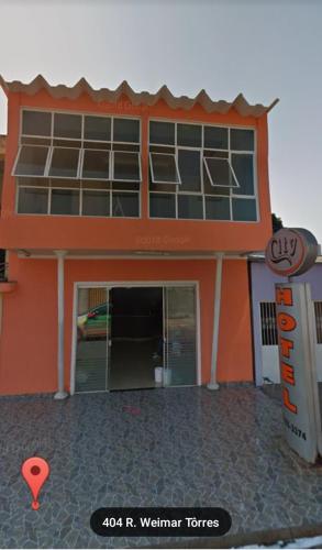um edifício laranja com um sinal em frente em CITY HOTEL em Várzea Grande