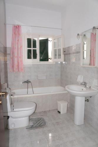 a bathroom with a tub and a toilet and a sink at Eftihia Studios in Kavos