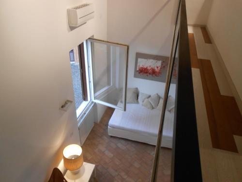 ローマにあるForo Romano Relaisの鏡と白いベッドが備わる屋根裏部屋