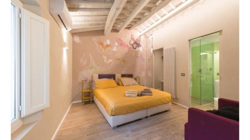 um quarto com uma cama com uma colcha amarela em Fonte Gaia Experience em Siena