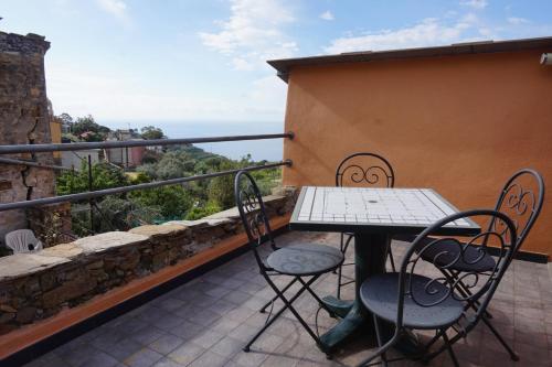a table and chairs on the balcony of a house at I Valloni Apartments in Imperia