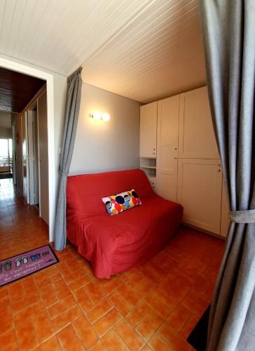 une chambre avec un lit rouge dans une pièce dans l'établissement Studio les Pieds dans l'Eau, à Six-Fours-les-Plages