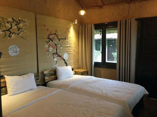 a bedroom with two beds and a window at May Homestay - Tam Coc Local Village in Ninh Binh