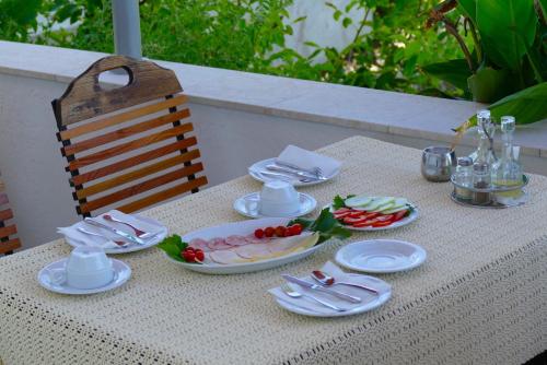 a table with plates of food on top of it at B&B Garni Stefi! in Supetarska Draga
