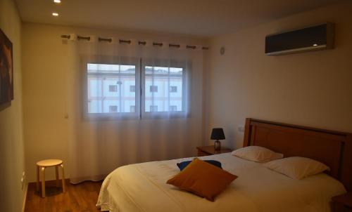 een slaapkamer met een bed en een raam bij Quarportugal in São Martinho do Porto