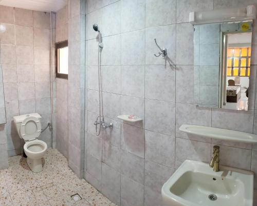 een badkamer met een douche, een toilet en een wastafel bij Hotel Les Fleurettes in Ouagadougou