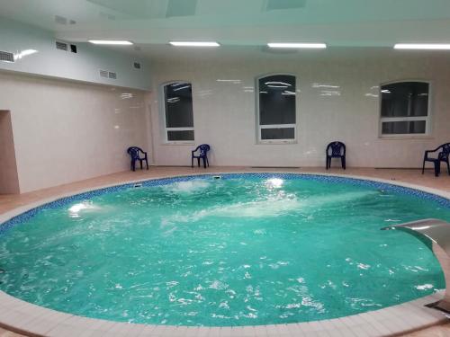a large swimming pool with chairs in a room at Park-Hotel Diyevo Gorodishche in Yaroslavl