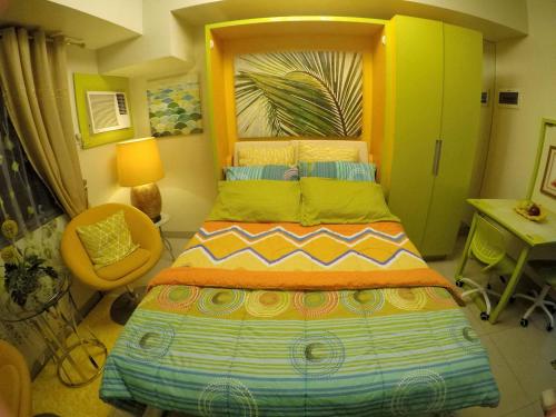 um quarto com uma cama grande e uma cabeceira amarela em JDT's Condo at Horizons 101 Cebu em Cebu