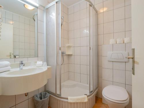 a bathroom with a shower and a toilet and a sink at Hotel Johannes-Zeche in Illmitz