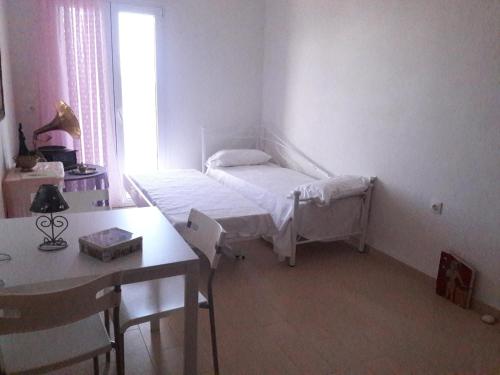 1 dormitorio con cama, mesa y escritorio en Alexia's house, en Chortáta