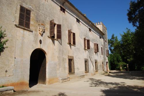 ein altes Steingebäude mit einem Torbogen und Fenstern in der Unterkunft Finca Son Vivot in Inca