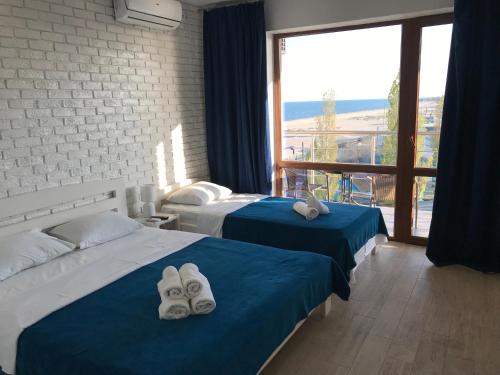 a hotel room with two beds and a large window at Золотий ЛЕВ in Zatoka
