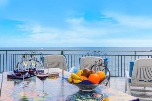 a table with a bowl of fruit on a balcony at Hotel Villa Maria Pia in Praiano