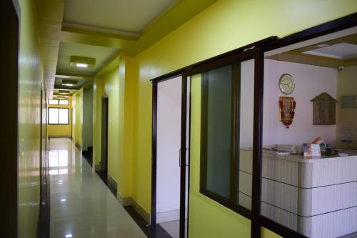 a hallway with yellow and green walls and a clock at Jupiter Lodge in Siliguri