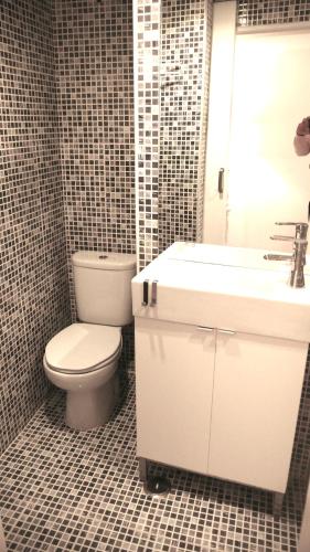 a bathroom with a white toilet and a sink at Oliveirinha in Lisbon