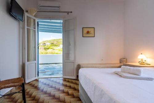 a bedroom with a bed and a sliding glass door at Iliopoulou Studios in Pollonia