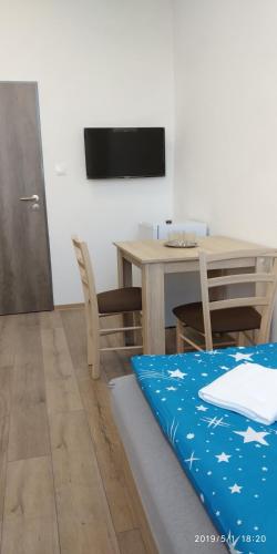 a dining room with a table and a tv at WHITE CORAL CLUB in Košice