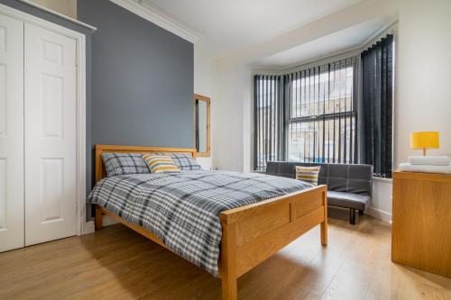 um quarto com uma cama, uma cadeira e uma janela em PLATFORM Fishing Quarter Apartment 1 em Hull
